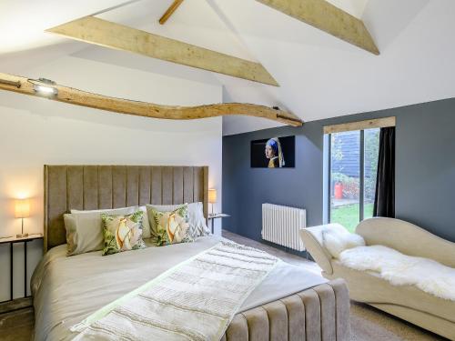 um quarto com uma cama grande e um sofá em 1 Lamb Barn em Saint Osyth