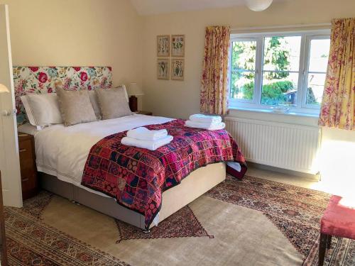 a bedroom with a bed with two towels on it at Orchard House in Baconsthorpe