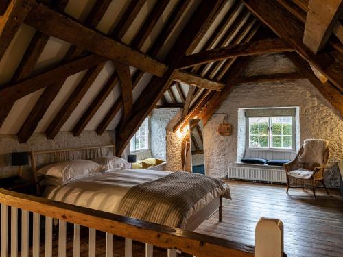 - une chambre mansardée avec un grand lit dans l'établissement The Stables At Daubeneys, à Colerne