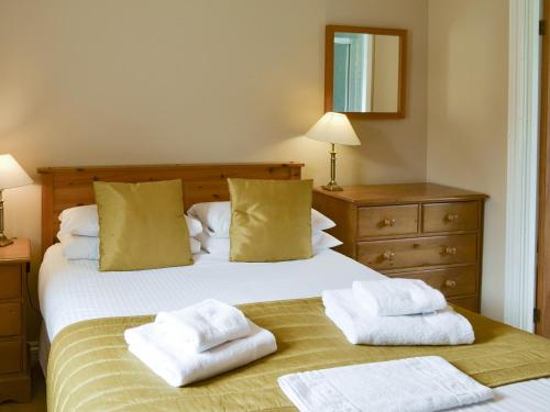 1 dormitorio con 1 cama con toallas en Fordson, en Warenford