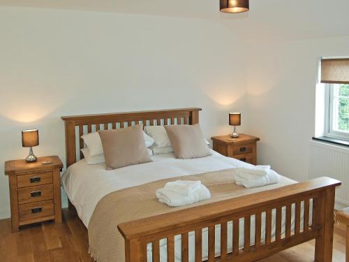 a bedroom with a bed with two towels on it at Home Park Farm Cottages B in Lanteglos