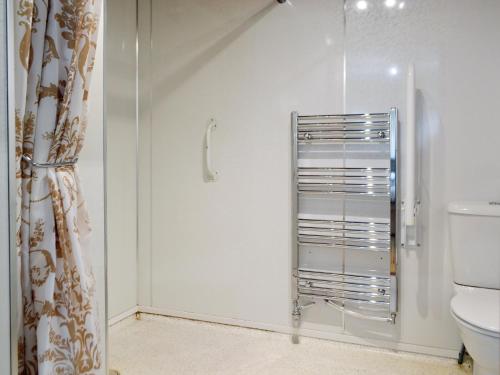 uma casa de banho com um WC e uma porta de duche em vidro. em Seabreezes - Uk30690 em Portknockie