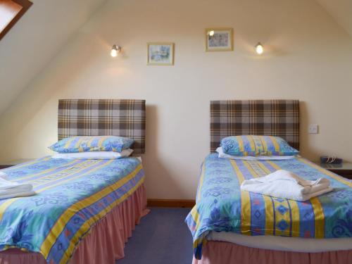 two beds sitting next to each other in a room at Seabreezes - Uk30690 in Portknockie