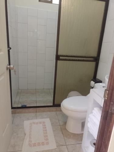 a bathroom with a toilet and a glass shower at Hotel San Rafael Ecolodge in San Gerardo