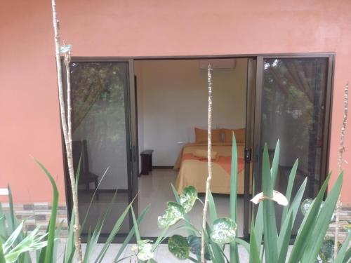 a room with a bed and a glass door at Hotel San Rafael Ecolodge in San Gerardo