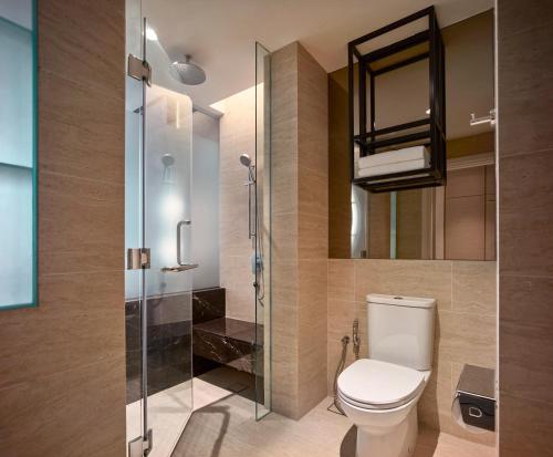 a bathroom with a toilet and a glass shower at Hotel Stripes Kuala Lumpur, Autograph Collection in Kuala Lumpur