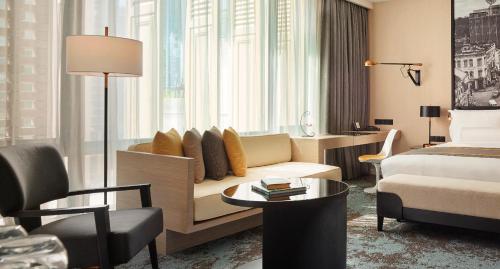 a hotel room with a couch and a bed at Hotel Stripes Kuala Lumpur, Autograph Collection in Kuala Lumpur