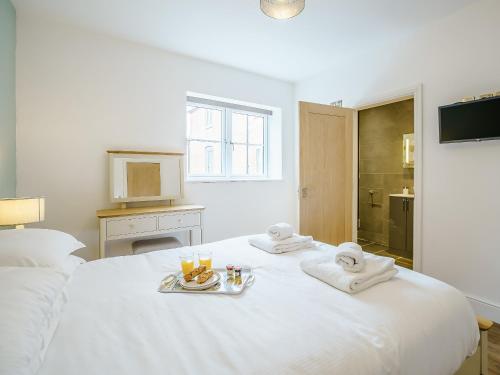 - une chambre blanche avec un lit, des serviettes et des boissons dans l'établissement Ty Felin - Uk12744, à Acrefair