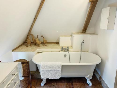 a bathroom with a white bath tub in a attic at North Barn in Tolpuddle