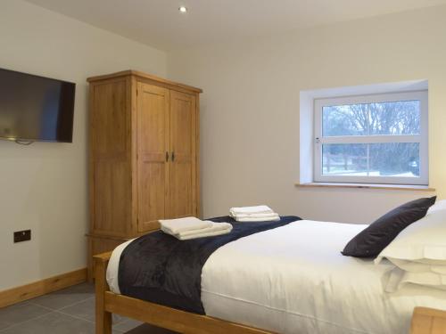 a bedroom with a large bed and a window at Stambar in Llanglydwen