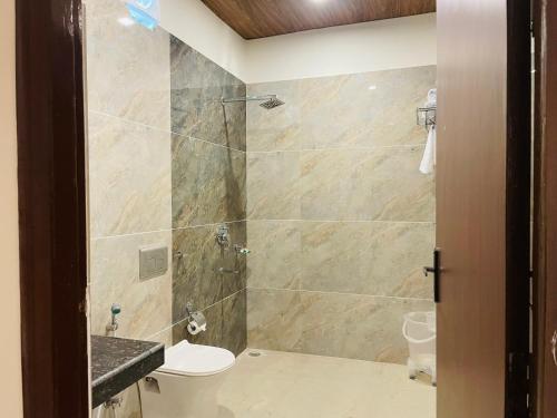een badkamer met een douche, een toilet en een wastafel bij The Deerfield Cottages in Rāmnagar