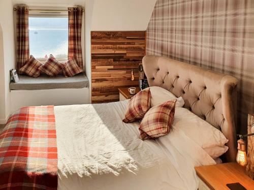 a bedroom with a bed with two pillows and a window at Ratagan Lodge in Kintail