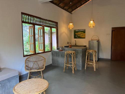 a kitchen with chairs and a counter with a refrigerator at Anestwella in Tangalle
