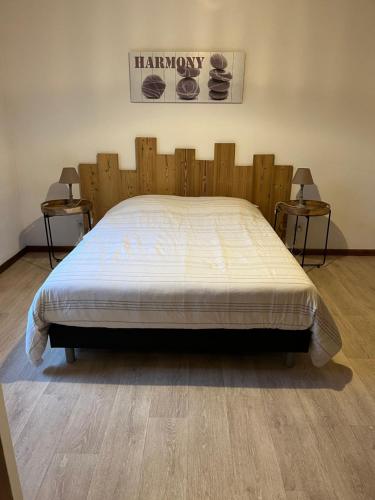 a large bed in a room with two side tables at Les mimosas in La Bresse