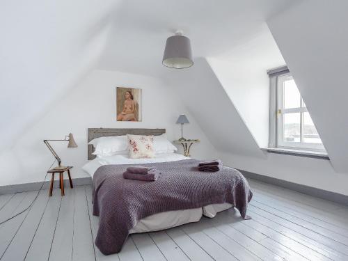 洛欣弗的住宿－Seafield House，白色卧室配有一张大床和毛巾