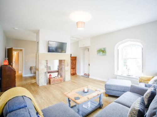 a living room with a blue couch and a table at Glebelands Lodge in Alnwick