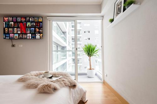 a bedroom with a bed and a large window at Skyliving Towers Apartments - Perú in Lima