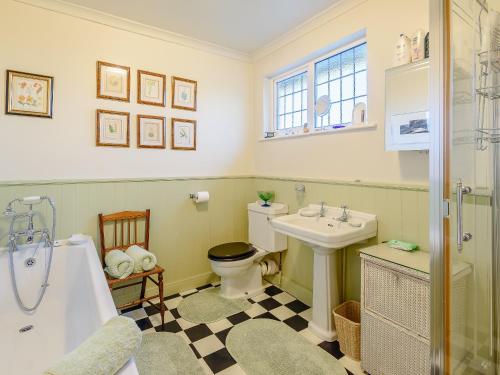 a bathroom with a toilet and a sink and a tub at Brandon in Sutton on Sea