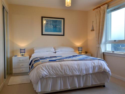 a bedroom with a bed with two night stands and a window at Brae Lodge in Cullen