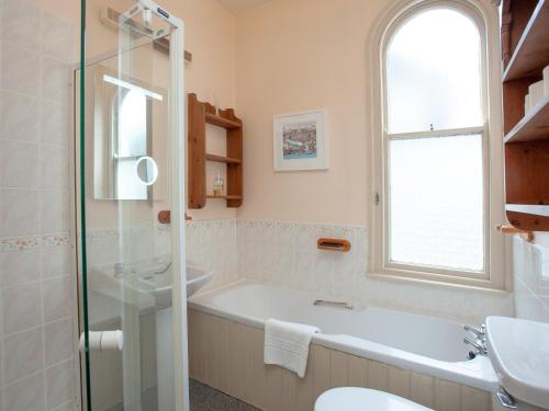 a bathroom with a bath tub and a sink at Dartview in Dartmouth