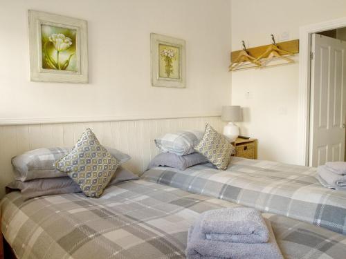 a bedroom with two beds with pillows on it at Gannet Lodge - Uk30977 in Bempton