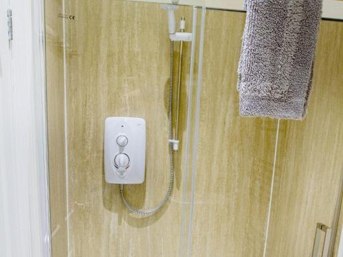 a bathroom with a shower with a plug in it at Gannet Lodge - Uk30977 in Bempton