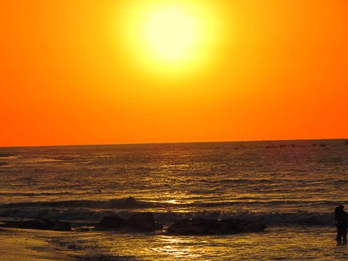 a person walking on the beach at sunset at Hotel El Murique in Zorritos