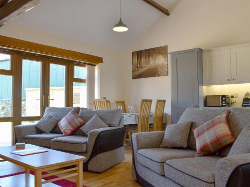ein Wohnzimmer mit 2 Sofas und einem Tisch in der Unterkunft Cider Press Barn - Uk12379 in Lydney