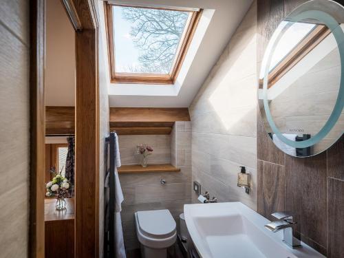 uma casa de banho com um WC, um lavatório e uma janela em Sycamore Barn - Uk33353 em Buttershaw