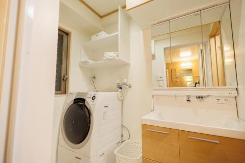 a bathroom with a washing machine and a sink at Hotaku House Akihabara #HO1 in Tokyo