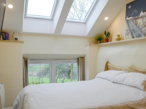 a bedroom with a white bed and a window at Dutch Barn One - Uk12872 in Brynkir