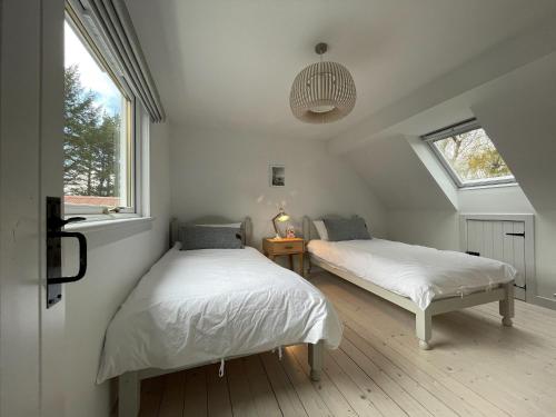 - 2 lits dans une chambre avec 2 fenêtres dans l'établissement Lower Hilton Cottage, à Culrain