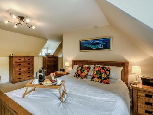 1 dormitorio con 1 cama grande y 1 mesa en The Mowle, en Ludham
