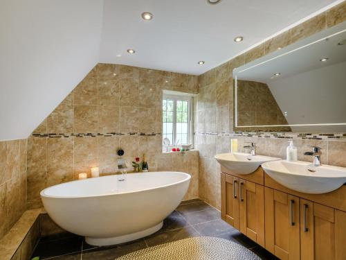 baño con 2 lavabos y espejo grande en The Mowle, en Ludham