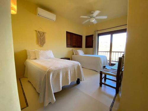 um quarto com 2 camas e uma ventoinha de tecto em Siete Piedras Beachfront Village em Troncones