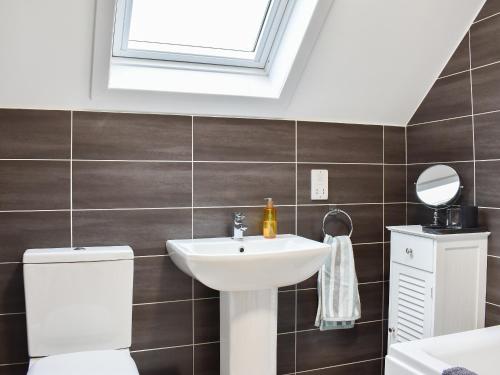 łazienka z umywalką, toaletą i oknem w obiekcie Ingleside w mieście Whiting Bay