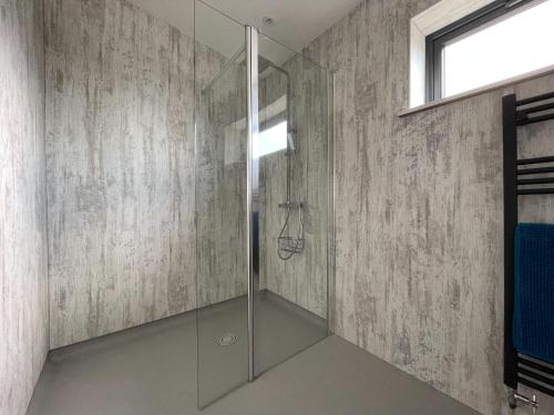 W łazience znajduje się prysznic ze szklanymi drzwiami. w obiekcie Willow Lodge w mieście Muir of Ord