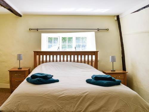 two blue towels on a bed in a bedroom at Plum Tree Cottage in Trent