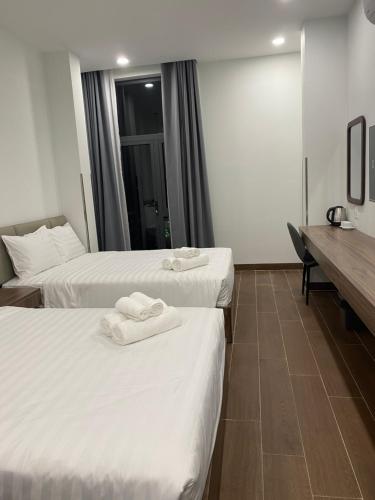 twee bedden in een hotelkamer met handdoeken erop bij Best Hotel in Ho Chi Minh-stad