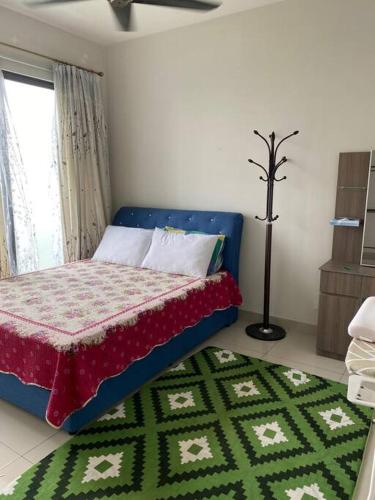 a bedroom with a bed with a green and white rug at The Makcik's @UNIV360 Serdang in Seri Kembangan
