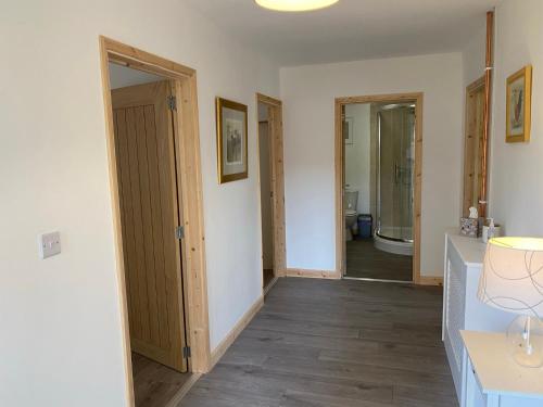 a hallway with a bathroom with a toilet and a sink at Mill View in Hickling