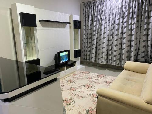 a living room with a couch and a tv at The Makcik's @UNIV360 Serdang in Seri Kembangan