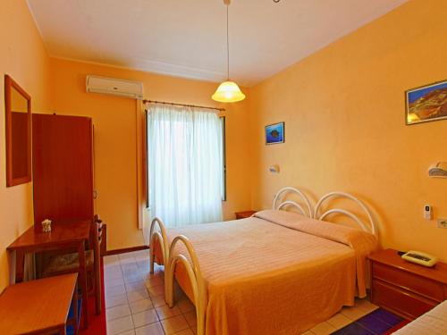 a bedroom with a bed with orange walls at Innpiero in Taormina