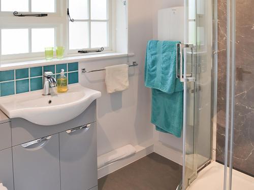 a bathroom with a sink and a shower at Willow Cottage in Ludham