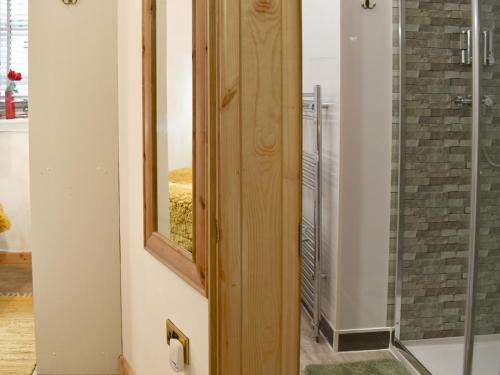 a bathroom with a shower and a glass door at The Archway in Newnham