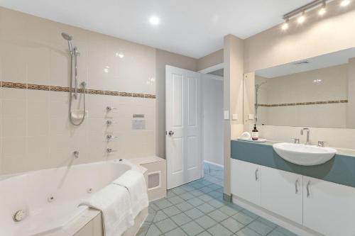 Baño blanco con bañera y lavamanos en Jervis Bay Vista en Huskisson