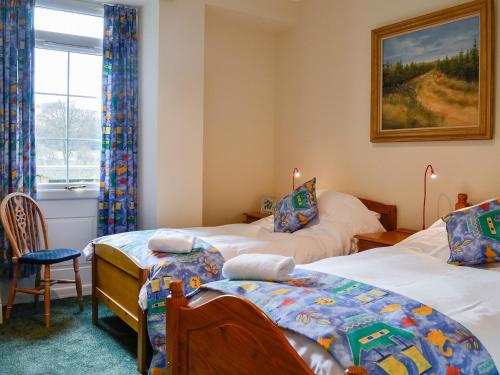 a bedroom with two twin beds and a window at Inverchroskie Cottage in Enochdhu