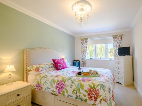 a bedroom with a bed and a dresser and a window at Holly Lodge in Hemsby