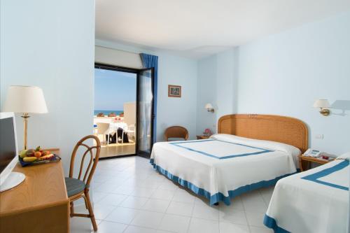 a hotel room with a bed and a table and a desk at Hotel Del Levante in Torre Canne