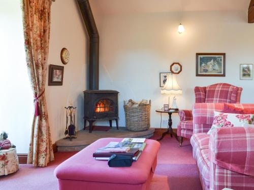 uma sala de estar com um sofá e uma lareira em Rambling Rose- Lwg em Ireby